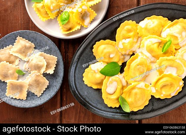 Italian Food. A closeup of an assortment of various ravioli, shot from the top on a dark rustic wooden background