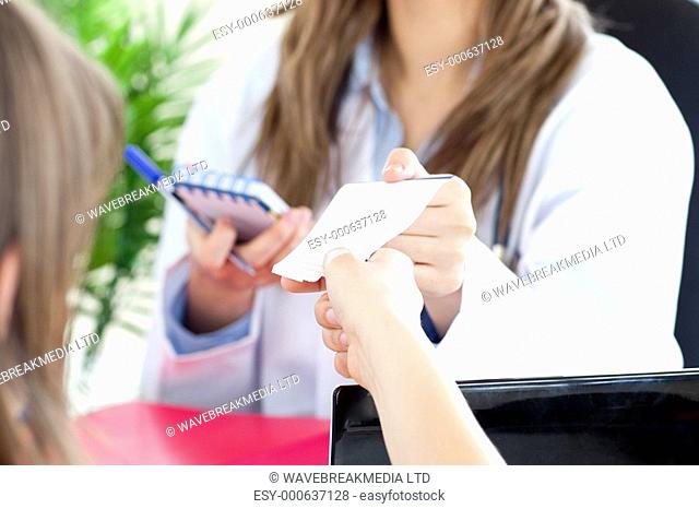 Radiant female doctor giving a paper to her patient in her office