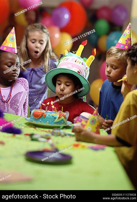 Boy blowing out birthday candles at party
