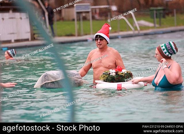 10 December 2023, Saxony-Anhalt, Osterwieck: Participants in the Advent swim stand in the water at 6 degrees Celsius in the Osterwieck outdoor pool