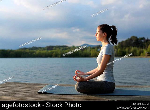 Profile of a woman doing yoga exercise in a lake