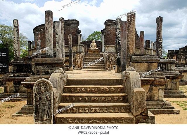 Buddha statue with ruined structure , World Heritage site , ancient city of Polonnaruwa , Sri Lanka