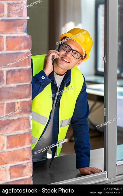 builder looking out window and calling on phone