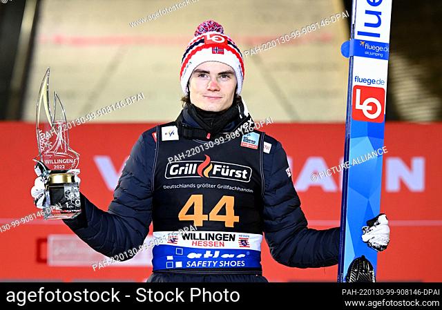 30 January 2022, Hessen, Willingen: Nordic skiing, ski jumping: World Cup, large hill, men. The winner Marius Lindvik from Norway holds his trophy during the...