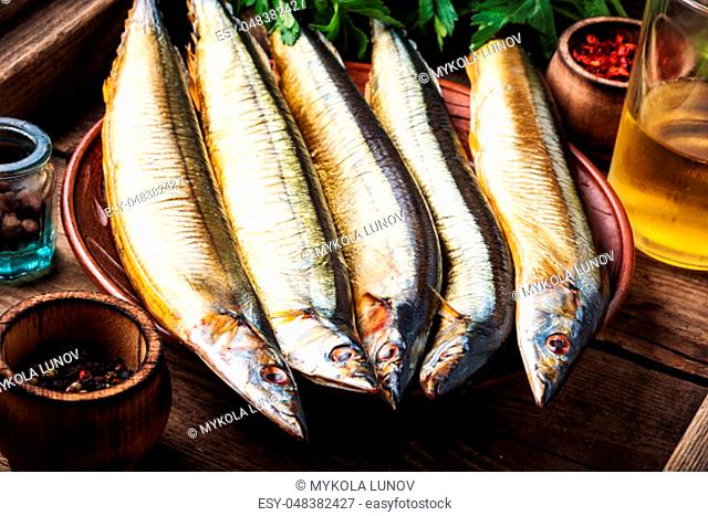 Appetizing smoked fish on kitchen board.Smoked saury.Smoked fish with spices