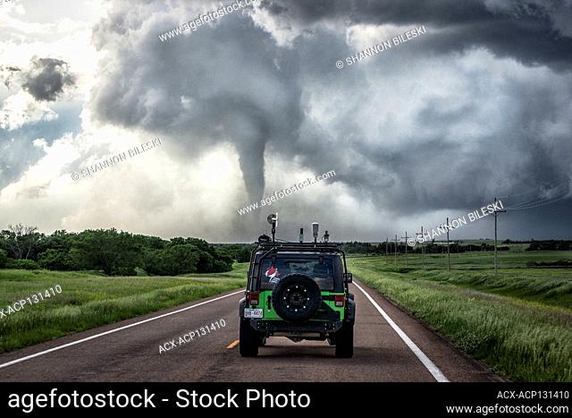 Tornado rips up dirt as Jeep drives towards the debris field near Hays Kansas United States