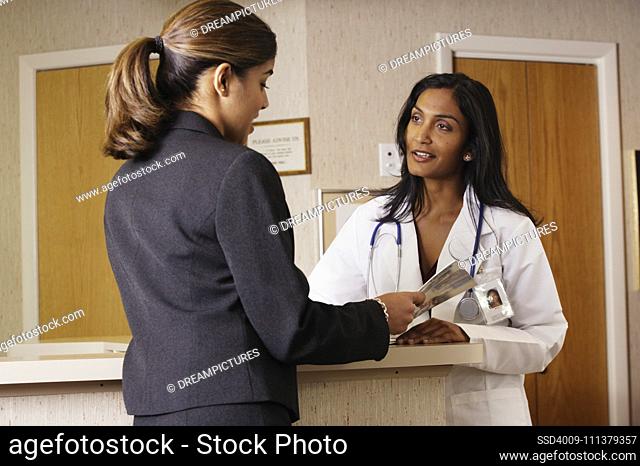 Doctor and businesswoman examining a brochure