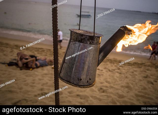 Unawatuna, Sri Lanka A kerosene lantern burns on the beach at sunset