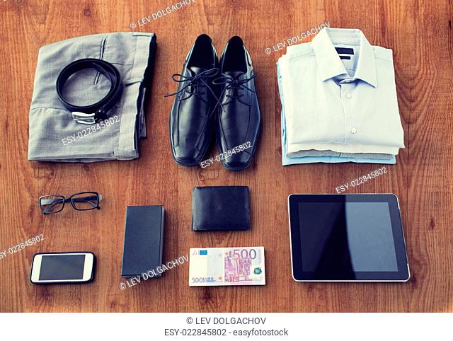 business, style, clothes and objects concept - close up of formal male clothes and personal stuff on wooden table at home