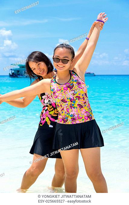 Female tourists mother and daughter in swimsuits smiling happily on the beach at Koh Miang island is a beautiful attractions famous of sea in Mu Ko Similan...
