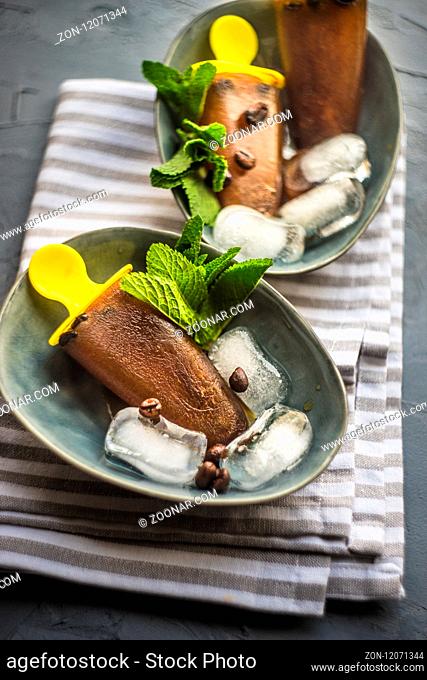 Summer dessert concept coffee lollypops with mint and ice on rustic background with copy space