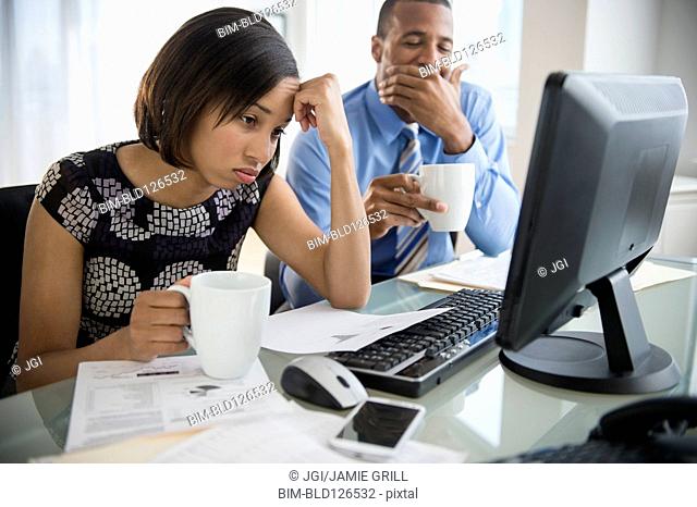 Exhausted business people with coffee working at computer