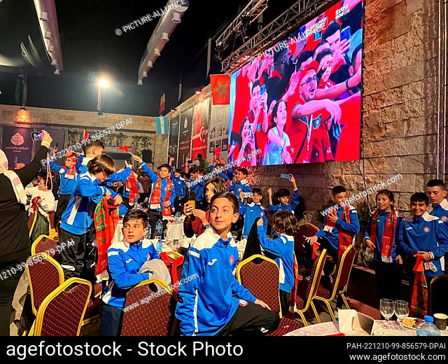 10 December 2022, Palestine. autonomous territories, Ramallah: Palestinian soccer fans of the Morocco national soccer team watch the Morocco - Portugal match at...