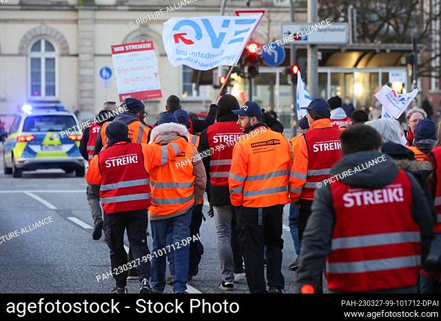 27 March 2023, Hamburg: Striking members of the EVG march with flags and strike vests from the main train station to the union building at Besenbinderhof