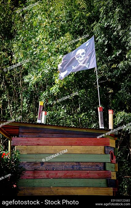 Ein aus bunten Brettern zusammengenageltes Baumhaus mit einer Piratenflagge