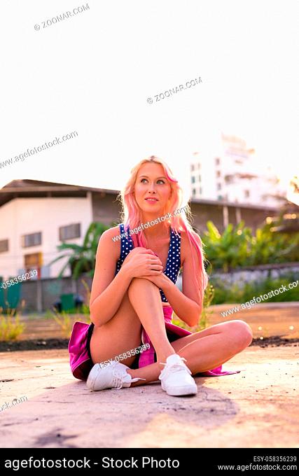 Portrait of young beautiful blonde woman exploring the city streets outdoors