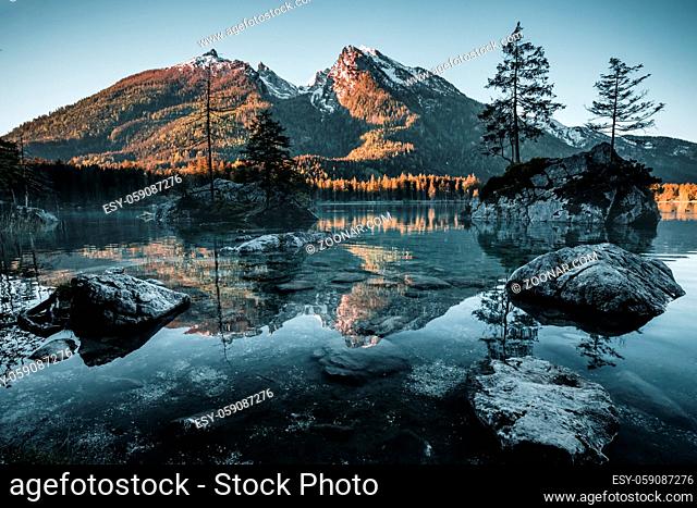 Amazing morning scenery on Hintersee Lake with alpine peaks reflected on the water during spring time