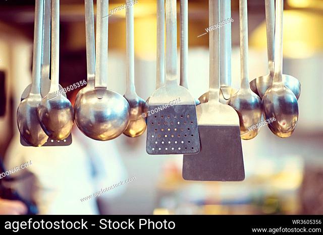 professional Cooking utensils hanging in a restaurant kitchen