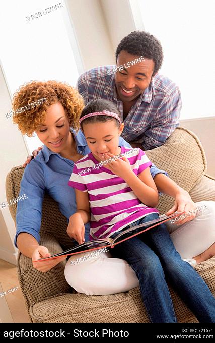 Parents with daughter reading book