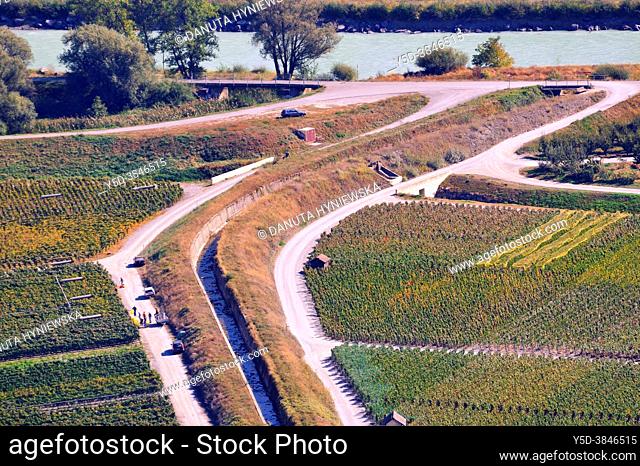 Harvest time in vineyards, view from above for vineyards and Bisse - irrigation ditch with water along the roadway, Bisses