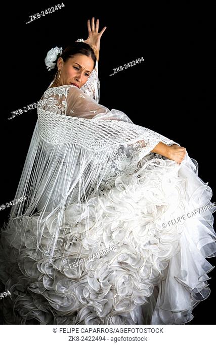 Flamenco dancer backs with white dress and hands crossed up on black background