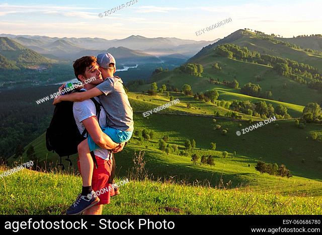 Travel, family and real life concept - happy father and son on the altai mountains background