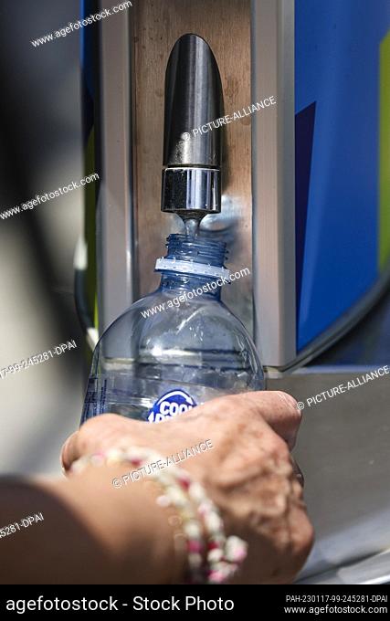 17 January 2023, Australia, Melbourne: A woman fills a bottle with water. Due to extreme temperatures, matches at the Australian Open were paused on the outdoor...