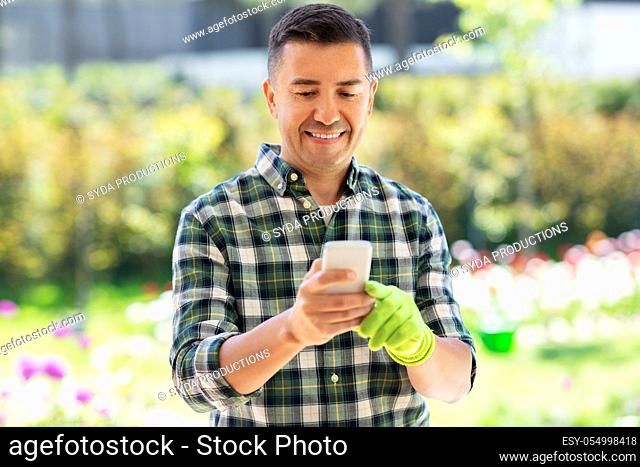 happy man with smartphone at summer garden