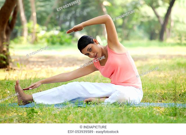 Smiling young woman doing stretching exercise