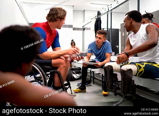 Paraplegic and amputee athletes talking in locker room