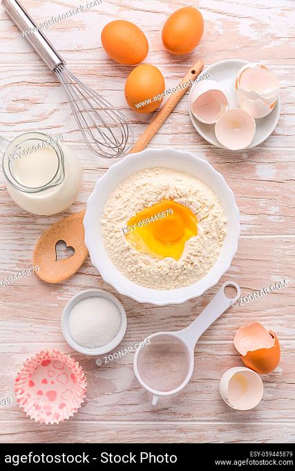 Assortment of basic baking ingredients for cake or pancakes on wooden background