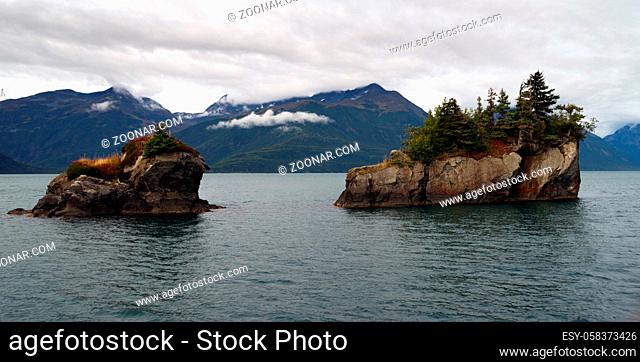 Clouds hang low over the mountains and rocky buttes in Resurrection Bay Alaska