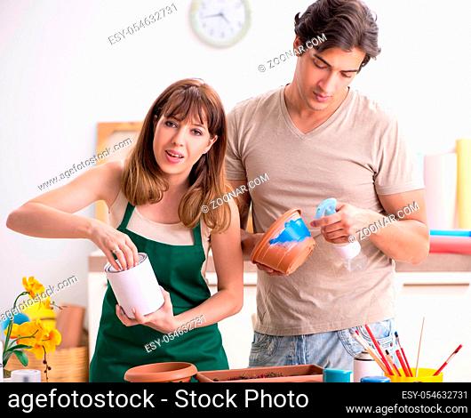 The couple decorating pots in workshop during class