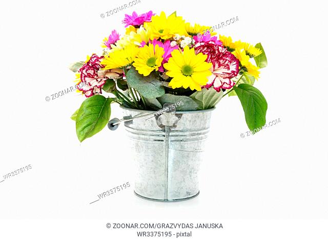 Bouquet from various flowers in a metal bucket, isolated on white background