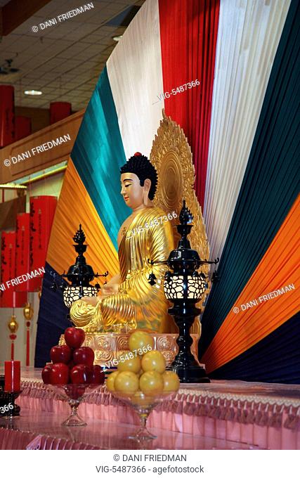 Buddha statue with offerings at the Fo Guang Shan Buddhist Temple in Mississauga, Ontario, Canada. - MISSISSAUGA, ONTARIO, CANADA, 06/02/2016