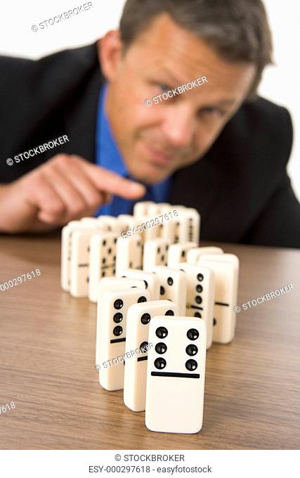 Businessman Playing With Dominos