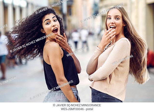 Portrait of two astonished young women on the street