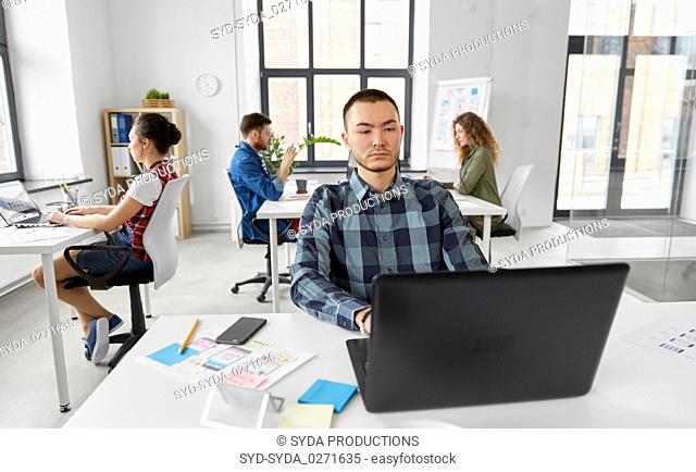 creative man with laptop working at office