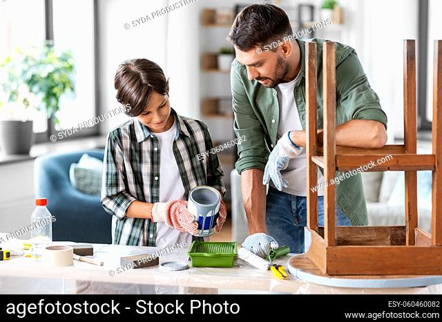 father and son pouring grey color paint into tray