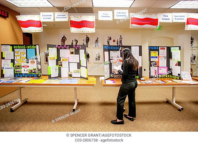 A teacher reads literature from counselors as they meet with local teachers at a community open house at school district headquarters in San Juan Capistrano, CA