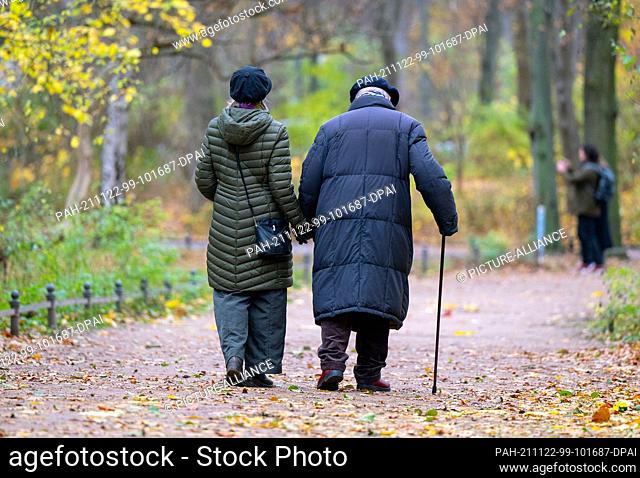 19 November 2021, Berlin: An elderly man with a walking stick and his companion walk through the zoo. Photo: Monika Skolimowska/dpa-Zentralbild/ZB