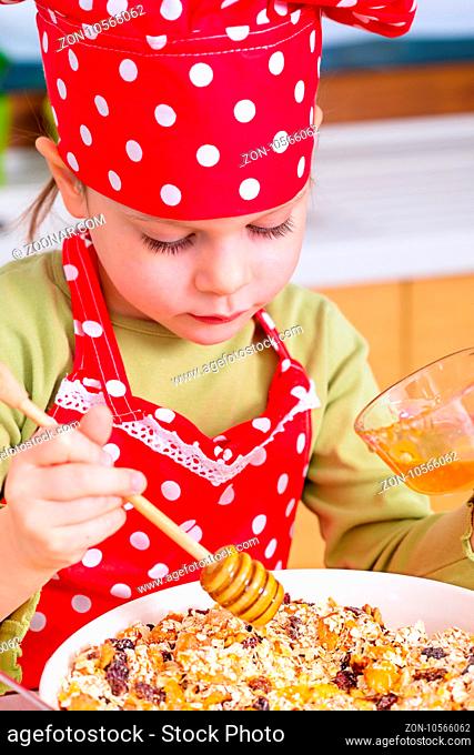 Girl preparing granola in the kitchen at home
