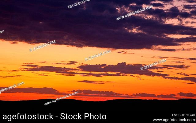 Colorful sky at sunrise with silhouetted hills