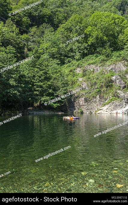 River Cannobino with bathing tourists near the church of Saint Anna in Valle Cannobina near Cannobio. Cannobio is a town in the Piedmont region in northern...
