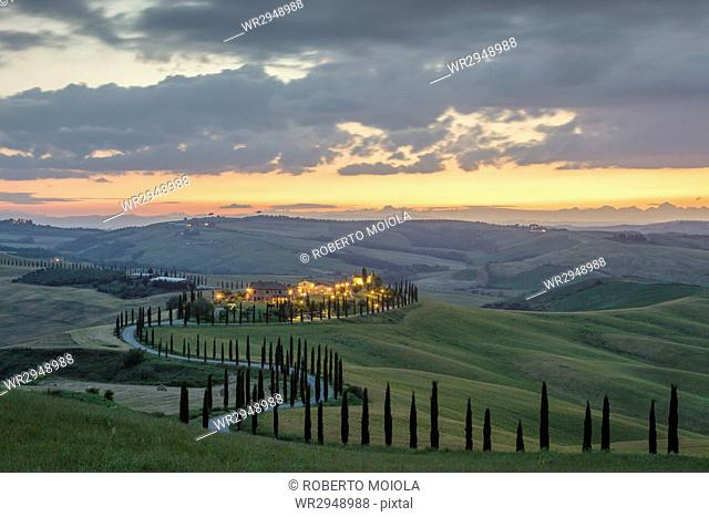 Dusk on green hills surrounded by cypresses and farm houses, Crete Senesi (Senese Clays), province of Siena, Tuscany, Italy, Europe