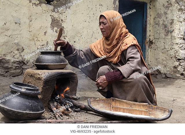 Muslim woman cooking on an earthen stove in a small village in Kargil, Ladakh, Jammu and Kashmir, India. (This image has a signed model release)