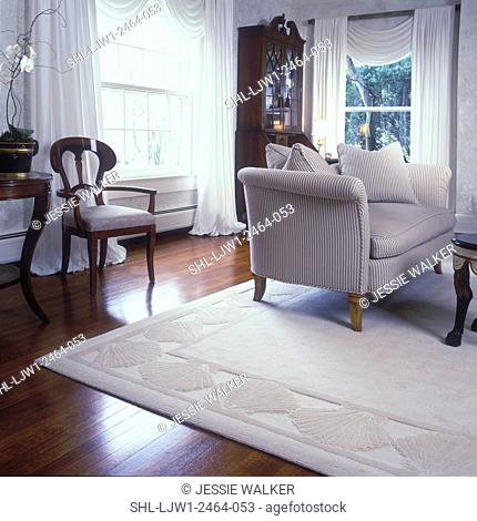 LIVING ROOMS - Off-white sculptured area rug, white walls, wood floors, traditional, upholstered love seat, beige, mahogany secretary