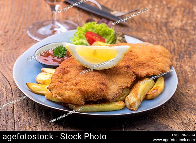 wiener schnitzel with fries on a plate