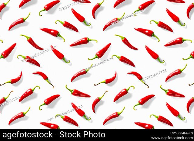 Creative background made of red chili or chilli on white backdrop. Minimal food backgroud. Red hot chilli peppers background, not pattern