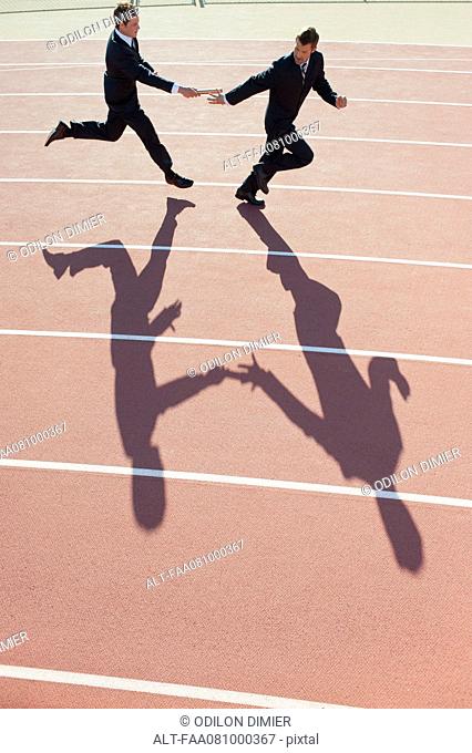 Businessmen running relay race